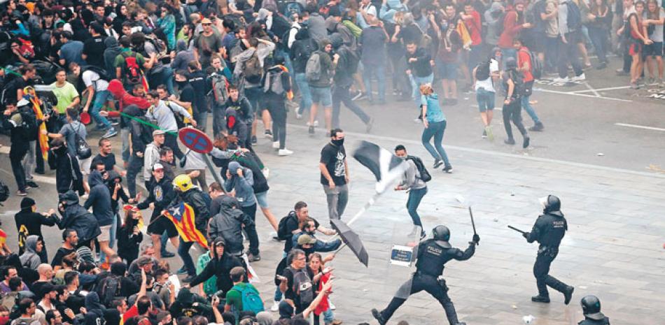Policías antimotines se enfrentan a manifestantes fuera del aeropuerto El Prat, en Barcelona. EFE
