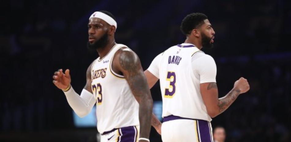 LeBron James y Anthony Davis de los Lakers de Los Ángeles durante la segunda mitad de un juego contra los Golden State Warriors en el Staples Center. Sean M. Haffey/AFP.