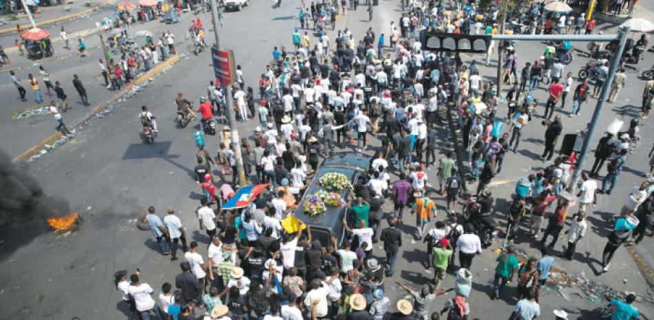 Cientos de personas participan ayer en el funeral del líder comunitario Josemano “Badou” Victorieux, en Puerto Príncipe, Haití. EFE