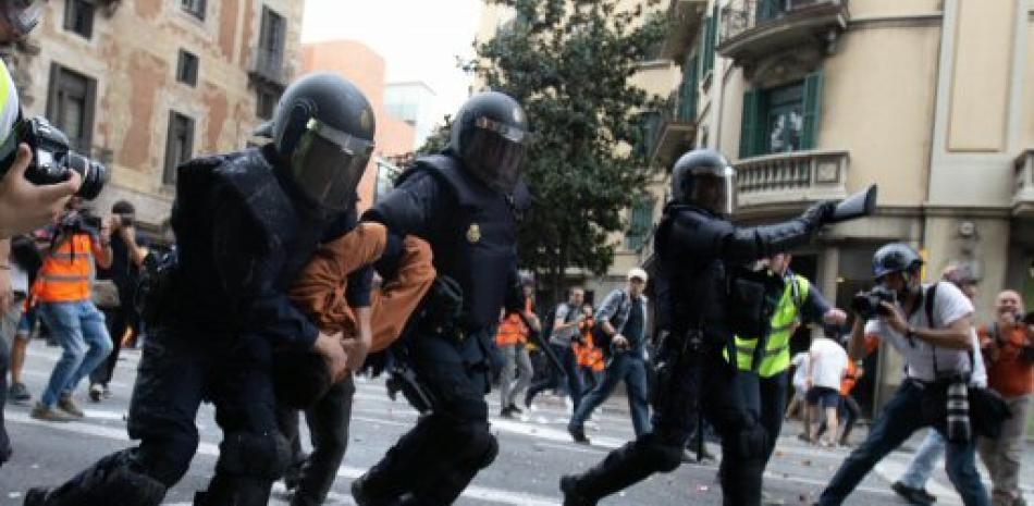 Agentes de la Policía Nacional detienen a un joven durante las protestas que se están produciendo ante la comisaria de la Policía Nacional de Via Laietana, en Barcelona, hoy viernes, el día en el que Cataluña vive su cuarta huelga general en menos de dos años vinculada al proceso independentista.