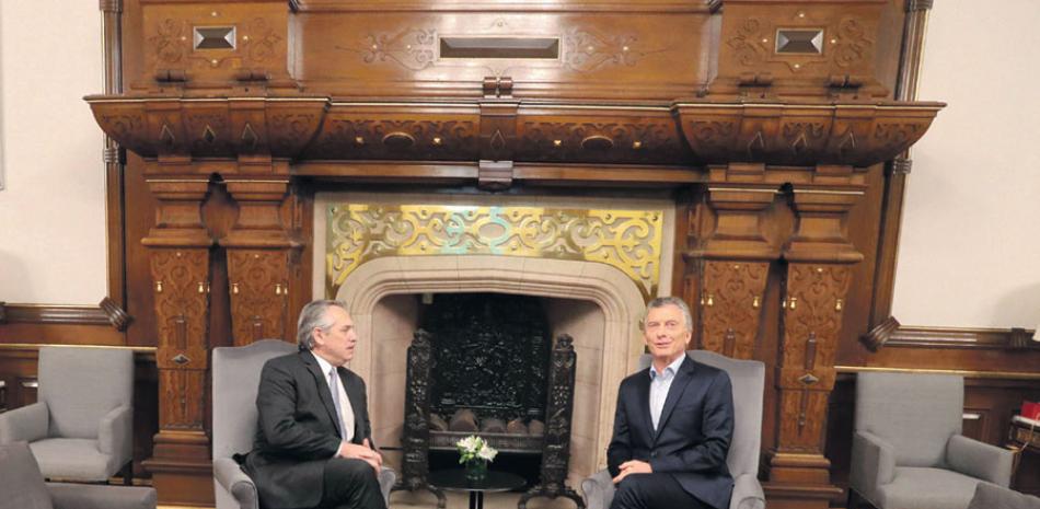 Alberto Fernández, izquierda,mientras hablaba con Mauricio Macri, en la Casa Rosada, ayer. EFE