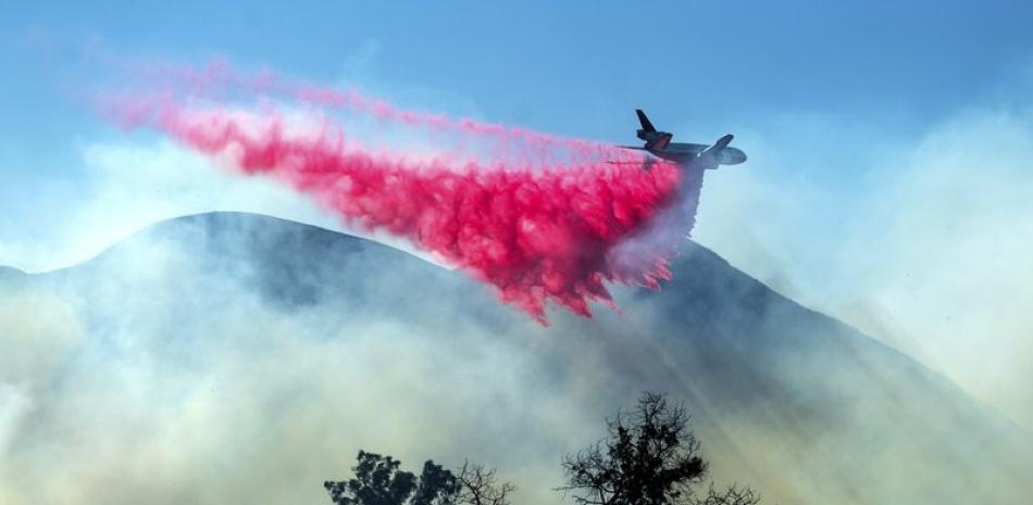 Un avión cisterna deja caer retardante sobre el incendio María cerca de Santa Paula, California,