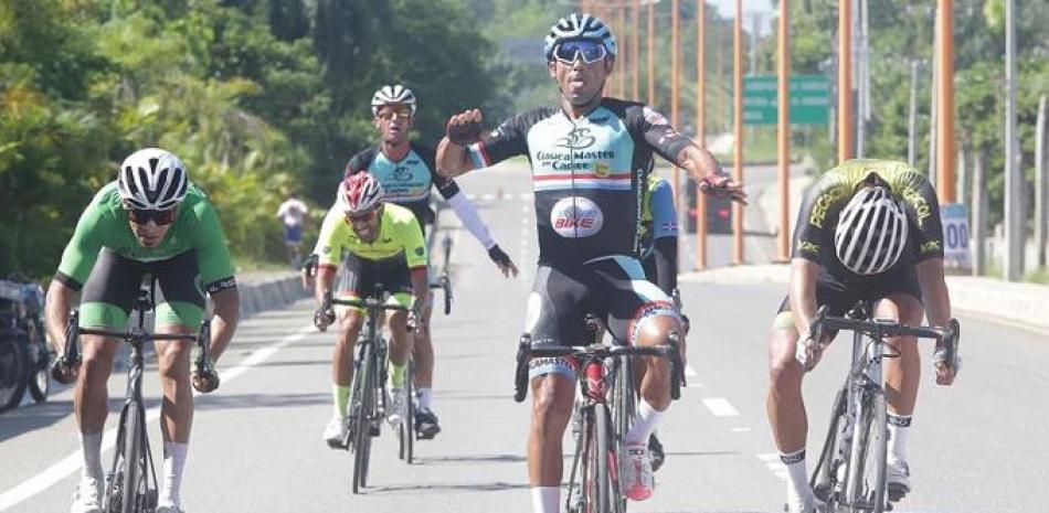 Arnold Arcolea levanta los brazos al momento de arribar a la meta en la primera posición en la categoría A de la primera etapa del campeonato de Ciclismo Triple 100.
