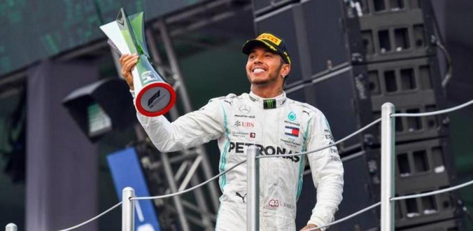 Lewis Hamilton exhibe el trofeo de campeón del mundo en Fórmula Uno.
