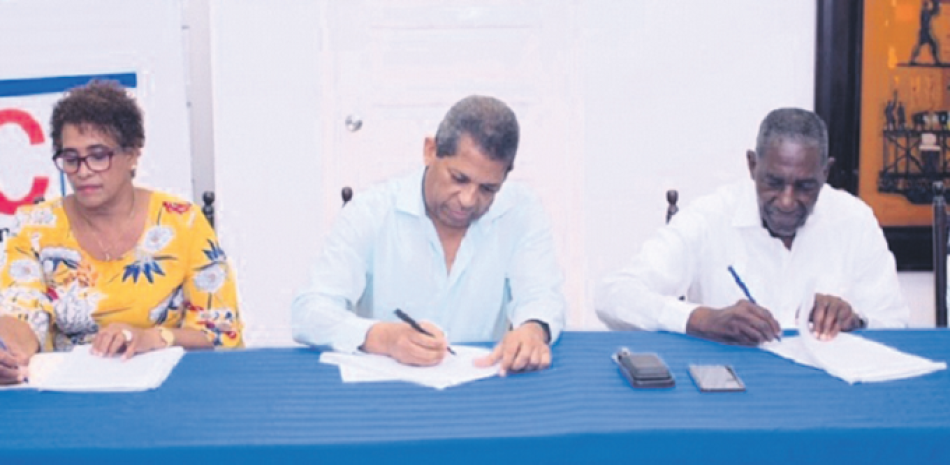 Eunice Magra, Eladio Uribe y Próspero Juan firman el Pacto Colectivo laboral entre Central Romana y el Sindicato Unido de Trabajadores. EF
