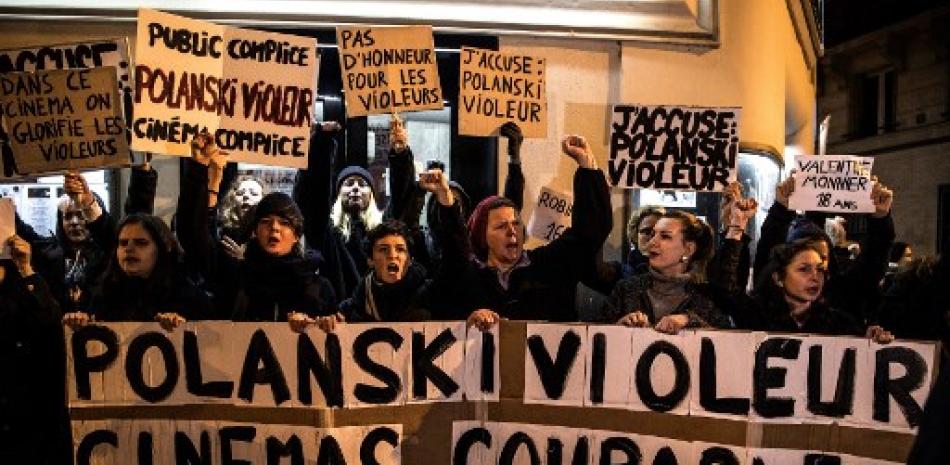 Manifestantes sostienen pancartas que dicen "Polanski violador, industria del cine culpable, el público es cómplice" durante una protesta contra el director de cine franco-polaco Roman Polanski. Christophe Archambault/AFP.