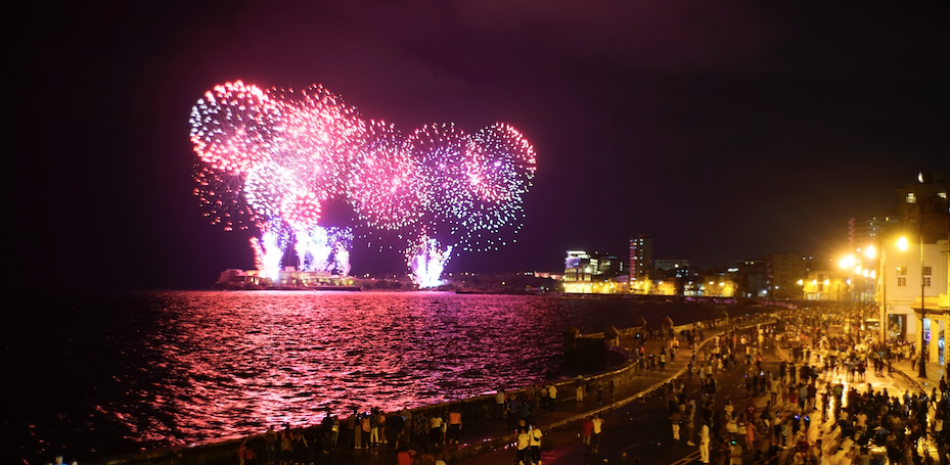 La gente camina a lo largo del malecón observando los fuegos artificiales como parte de la celebración de los 500 años de la ciudad de La Habana, Cuba, el viernes 15 de noviembre de 2019. (Foto AP/Ramon Espinosa)