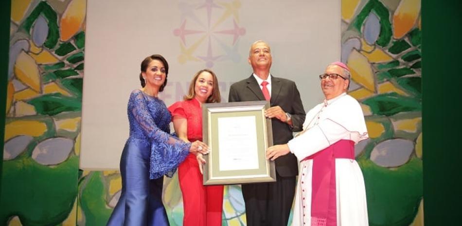 Ismael De la Rosa y Magdalena Viola reciben reconocimiento de  Cándida Montilla de Medina y Monseñor Benito Ángeles.