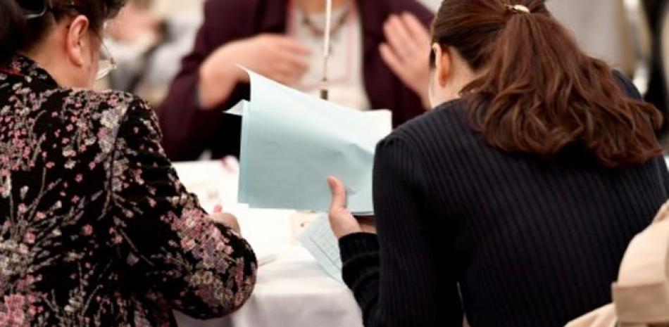 Una madre y su hija revisan una lista de asistentes a una fiesta para encontrar pareja el 3 de noviembre de 2019 en Tokio / AFP