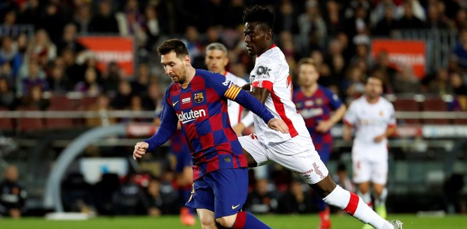 Lionel Messi deja atrás a dos defensas en la abultada victoria del Barcelona sobre Mallorca.