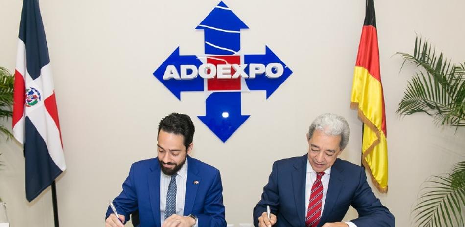 Los presidentes de Adoexpo y CC-DA Luis Concepción y Fabio Guzmán Saladín firman el acuerdo.