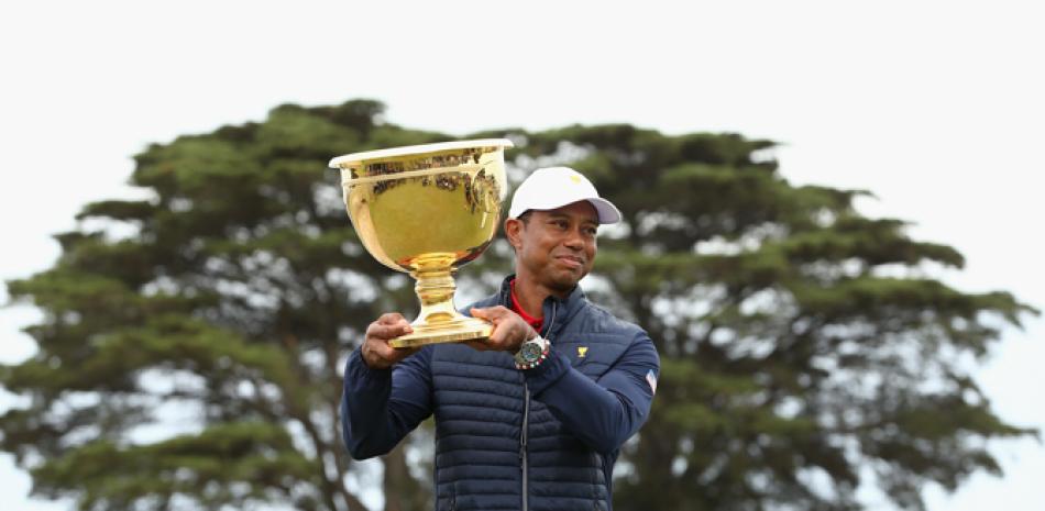 Tiger Woods eleva la copa ganada por Estados Unidos.