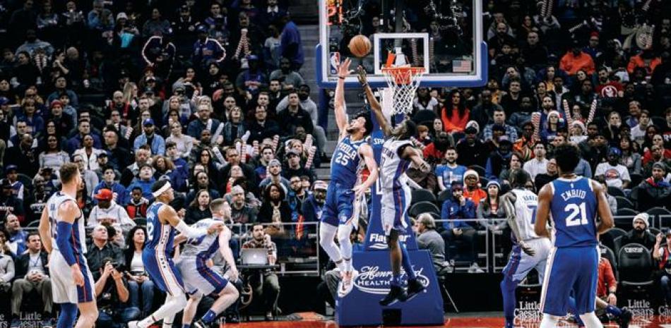 Ben Simmons, de Filadelfia, se eleva en busca de un canasto ante la defensa de Tony Snell, de los Pistons, durante el partido de anoche en el baloncesto de la NBA.