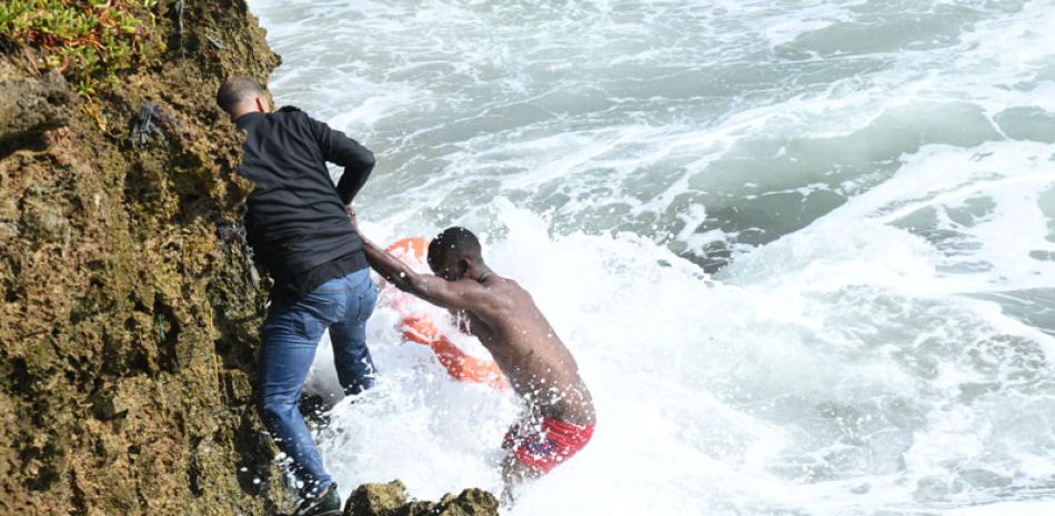 Un socorrista ayuda a sacar a Esmileidy Encarnación del mar Caribe, donde se metió voluntariamente a darse un baño. FOTO: LISTÍN DIARIO / RAÚL ASENCIO