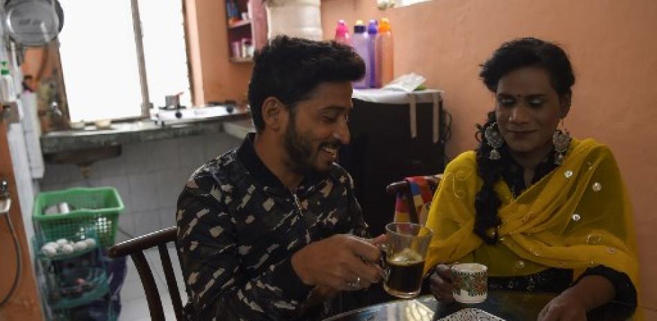 En esta imagen el artista de maquillaje, y miembro de la comunidad LGBT, Asim Nath (izquierda) bebe café junto con su compañera de piso transgénero, la también maquillista Tulsi Chandra en su departamento en Nueva Delhi. Prakash Singh/AFP.
