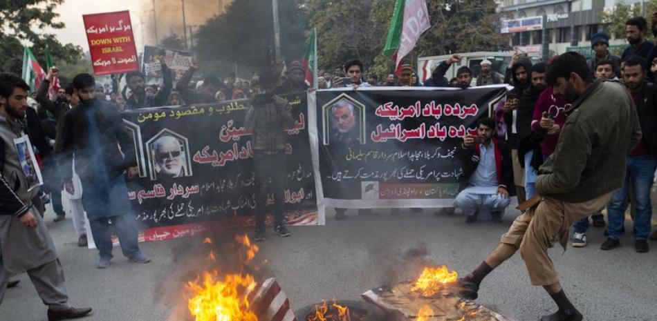 Unas personas queman banderas estadounidenses durante una protesta por el ataque de Estados Unidos que provocó la muerte del general iraní Qassem Soleimani, en Islamabad, Pakistán, el viernes 3 de enero de 2020. Foto: AP.