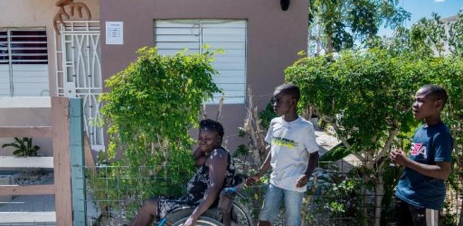 Herlande Mitile, 36, junto a dos de sus vecinos afuera de su casa en Puerto Príncipe. / AFP