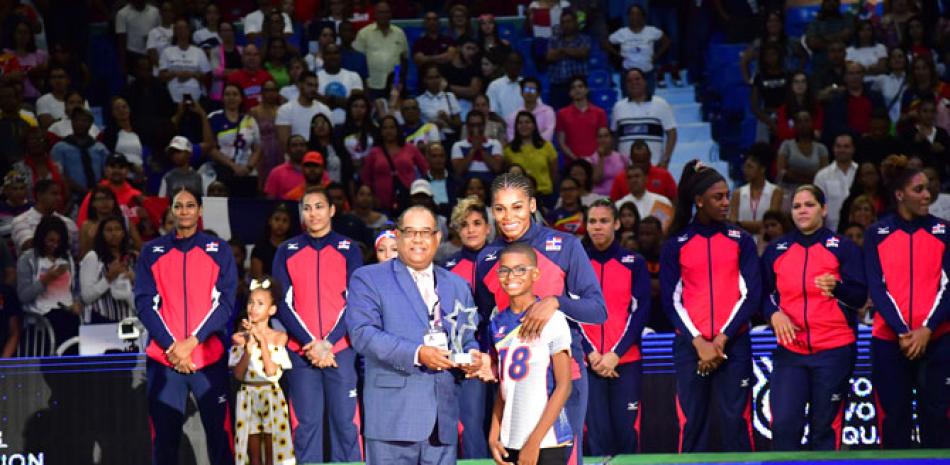 Alexis García, presidente de la Federación Dominicana de Voleibol, galardona a Bethania de la Cruz como Mejor Servicio del evento.