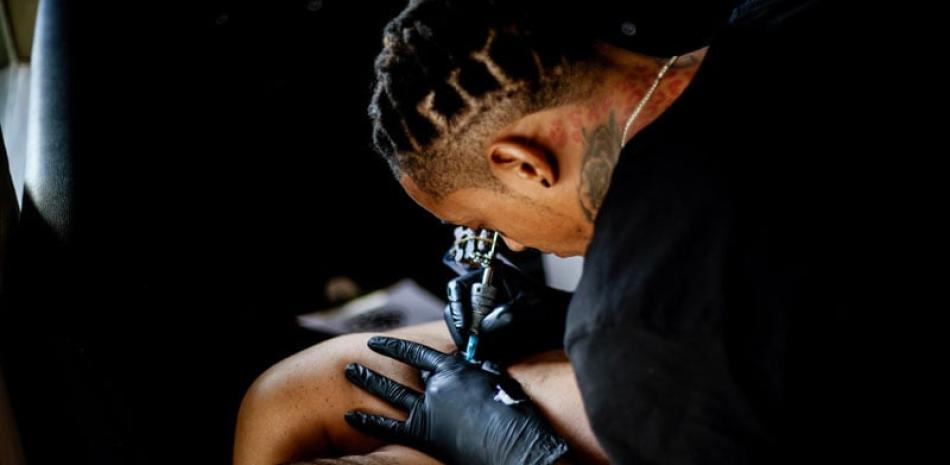 Ricardo Lara cuando realizaba un tatuaje en el centro “Body Art”.