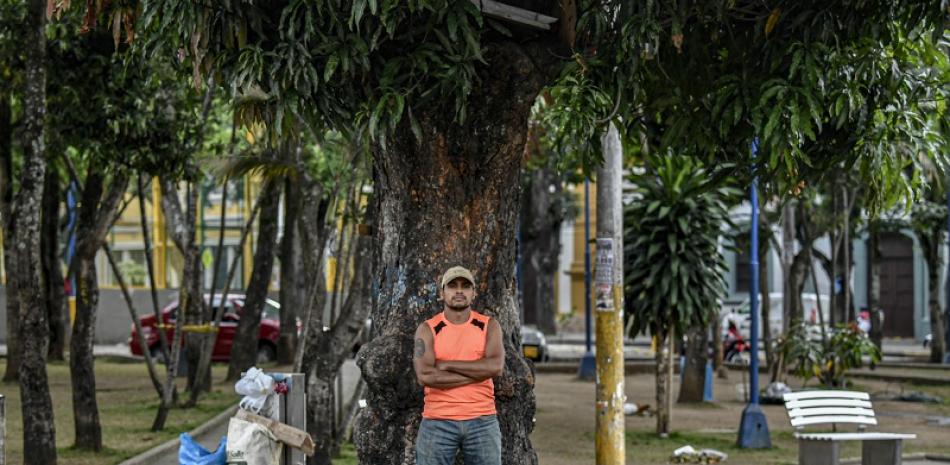 Migrante venezolano, Richard Álvarez, posa frente al árbol donde estableció su casa. Juan BARRETO / AFP