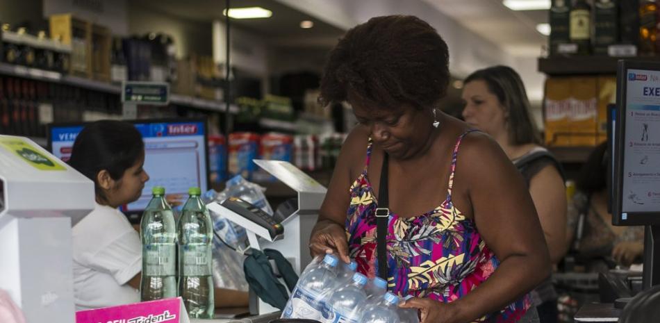 Marcia Helena compra agua embotellada en un supermercado en el barrio Copacabana en Río de Janeiro, Brasil, el miércoles 15 de enero de 2020. (AP Foto/Bruna Prado)