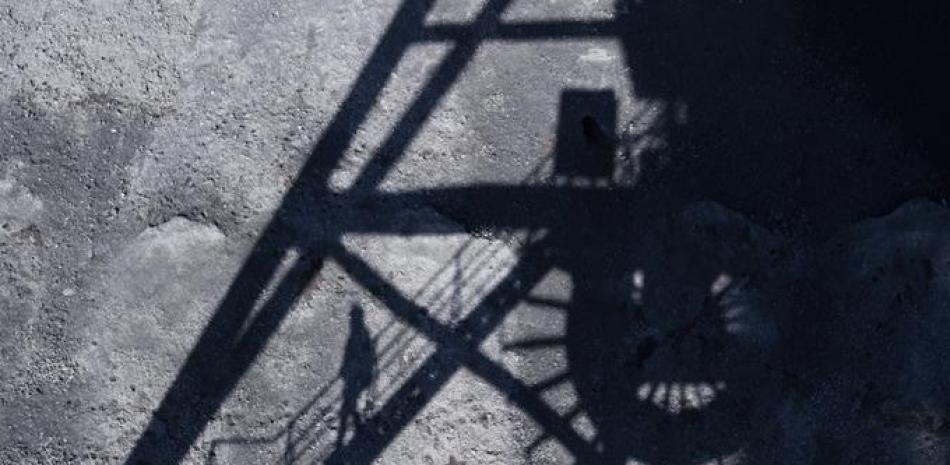 La sombra de un hombre se ve proyectada en la central eléctrica a carbón de Mehrum, en el distrito de Peine en Hohenhameln, Alemania, el miércoles 15 de enero de 2020. ( Julian Stratenschulte/dpa via AP)