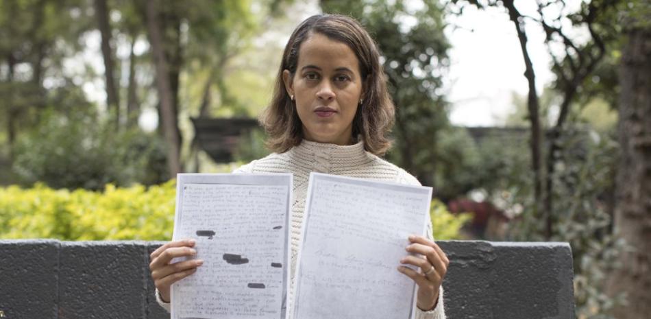 Una de las muejres abusadas muestra la carta donde relata la violacios. / AP