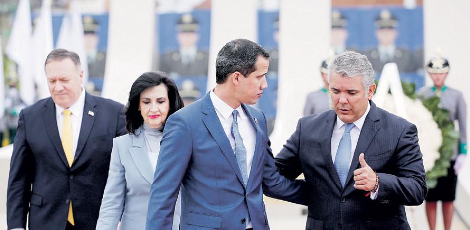 El presidente colombiano Iván Duque, derecha, habla con el opositor Juan Guaidó, en el centro, mientras el secretario de Estado de EE. UU. Mike Pompeo los sigue. AP