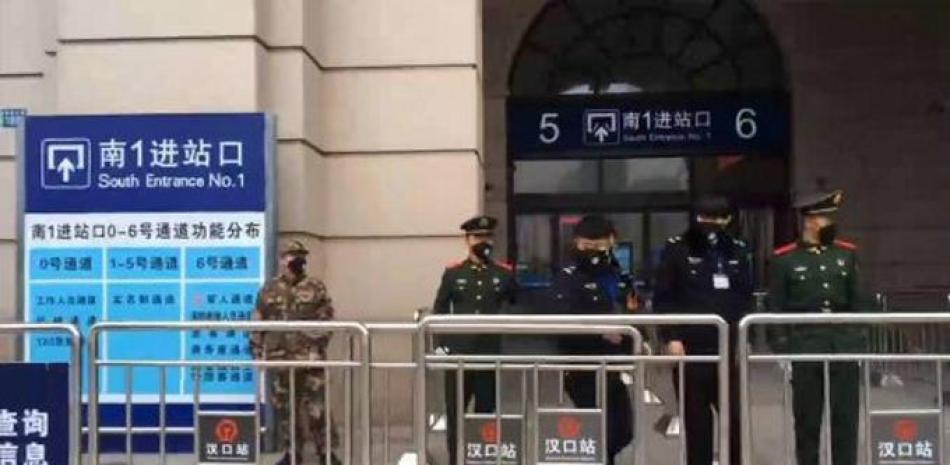 Guardias de seguridad mantienen vigilancia sobre una estación del tren cerrada en Wuhan, China. / AP