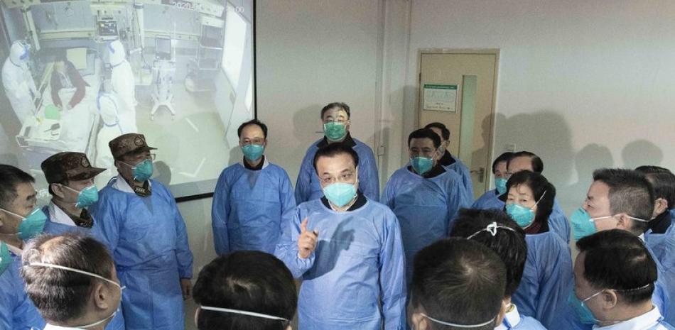 En esta fotografía publicada por la agencia noticiosa estatal Xinhua, el primer ministro chino Li Keqiang, al centro, habla con trabajadores médicos en el hospital Jinyintan en la ciudad de Wuhan, China, el lunes 27 de enero de 2020. Todos portan equipo protector contra un nuevo virus. (Li Tao/Xinhua vía AP)