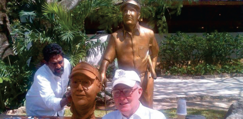 El Artístico, José Ignacio Morales, trabajando en la estatua que honra a Pete Dye y que se puede ver justo en la entrada al Pro Shop de Casa de Campo. En primer plano, Dye posando para el artista.