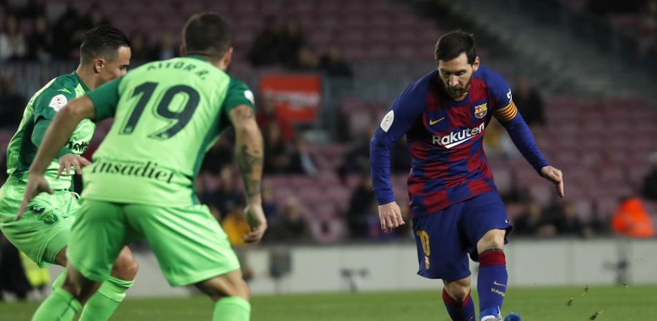 Lionel Messi intenta burlar la defensa de dos jugadores del Leganés en el primer tiempo del desigual encuentro.