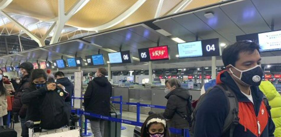 Viajeros se protegen con mascarillas en Aeropuerto chino. / AP