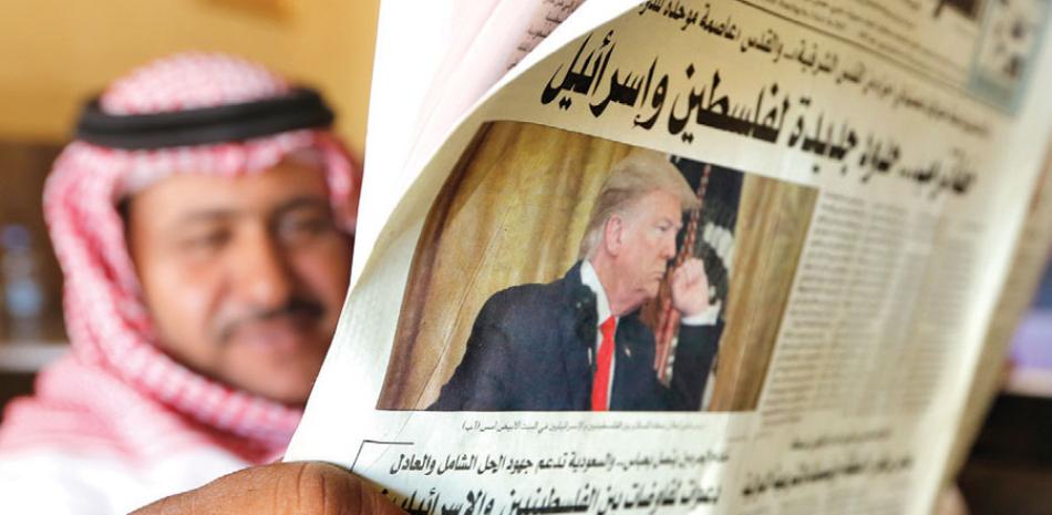Un hombre sostiene el diario Asharq Al-Awsat con una foto de Donald Trump, en Jiddah, Arabia Saudita. AP