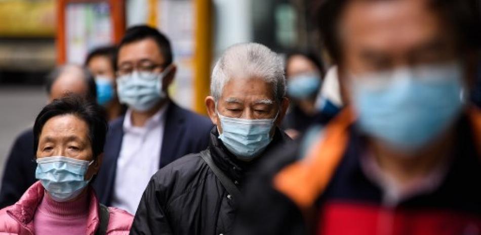 Peatones usando máscaras faciales en Hong Kong como medida preventiva luego de un brote de virus que comenzó en la ciudad china de Wuhan. Anthony Wallace/AFP.