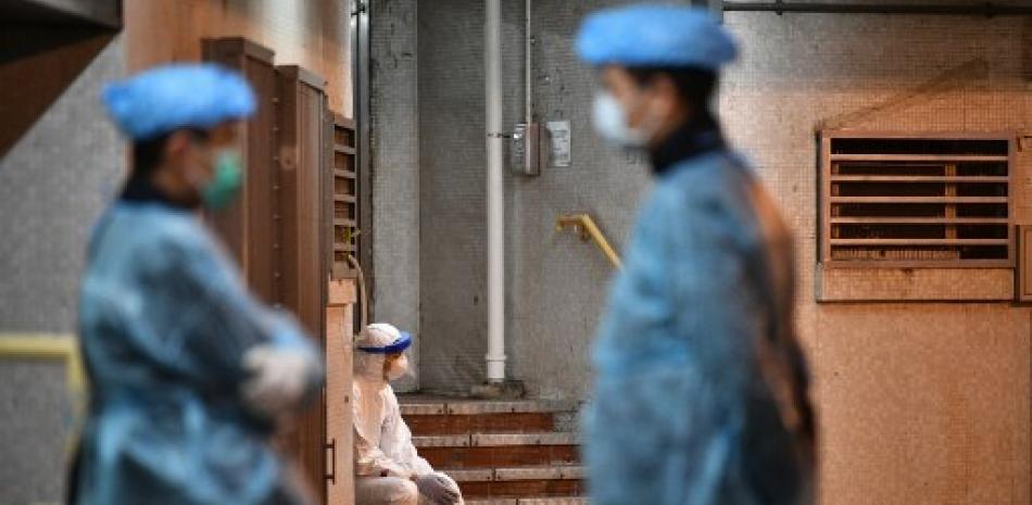 Médico a las afueras de un centro médico utilizando mascarillas. / AFP