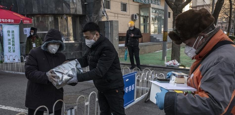 Las entregas son hechas en un punto designado afuera de un edificio en Pekín, el martes 18 de febrero de 2020. (Gilles Sabrie/The New York Times)