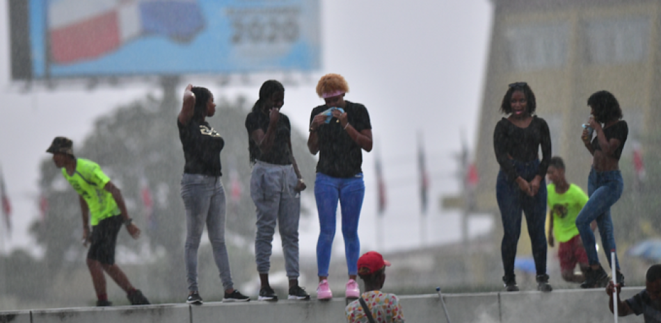 Jóvenes que protestan en la Plaza de la Bandera cuando se retiraban ayer ante la escasa asistencia provocada por las lluvias que azotaron la ciudad.
