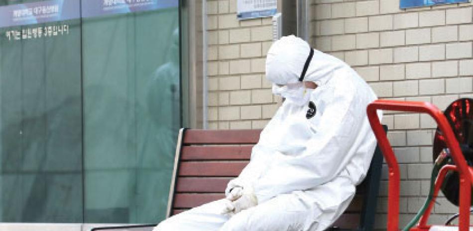 Un miembro del equipo médico se toma un descanso ante un hospital en Daegu, Corea del Sur.