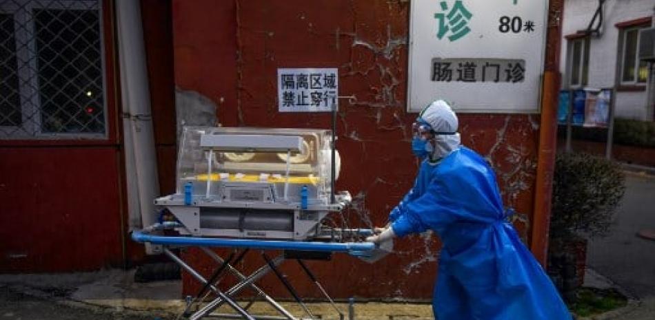 Médico en las afuera de un hospital en China. / Listín