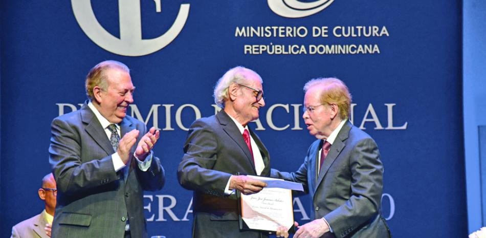 El escritor Juan José Jimenes Sabater (León David) recibe de manos del empresario José Luis Corripio Estrada (Pepín) la placa que lo acredita como Premio Nacional de Literatura 2020. A su lado Eduardo Selman, ministro de Cultura GLAUCO MOQUETE/LISTÍN DIARIO