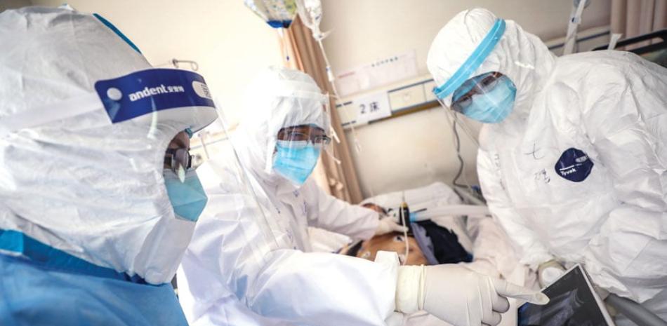 Médicos asisten a un paciente en Wuhan, China. / AFP
