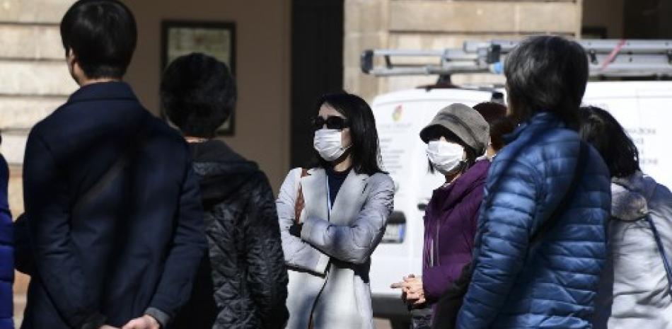 Personas utilizando mascarillas para prevenir el coronavirus. / AFP