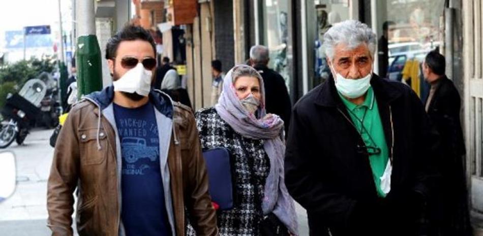 Personas con mascarillas pasean por Teherán. / AFP