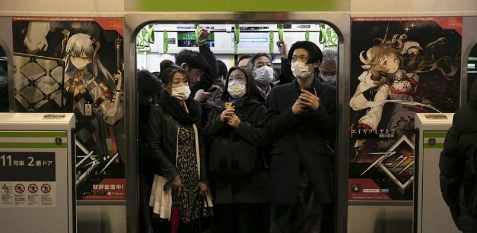 Usuarios del transporte público con máscaras en un tren abarrotado en la estación de Shinagawa, en Tokio, el lunes 2 de marzo de 2020. (AP Foto/Jae C. Hong)