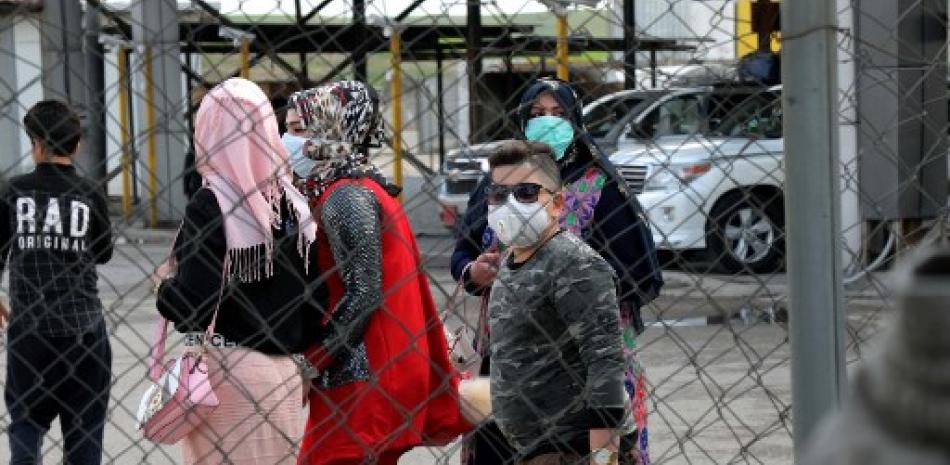 Los viajeros que llegan al puesto de control de Arbil, la capital de la región autónoma kurda iraquí del norte, esperan que se les controle la temperatura, el 2 de marzo de 2020, como medida para prevenir un nuevo brote de coronavirus. Safin Hamed/AFP.