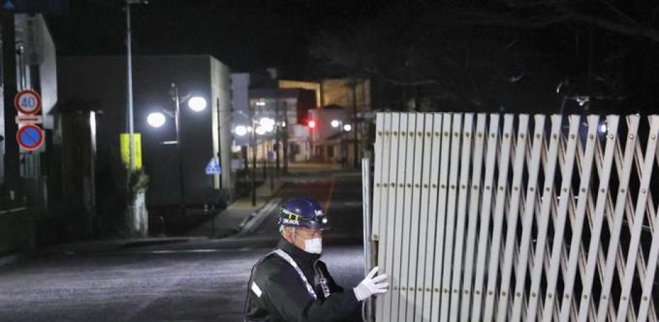 Un guardia abre la reja a la entrada de la ciudad de Futaba, en la prefectura de Fukushima, Japón, el miércoles 4 de marzo del 2020. El gobierno levantó parcialmente la prohibición de entrada a Futaba, la última ciudad con acceso restringido a raíz del desastre nuclear de 2011. (Kyodo News vía AP)