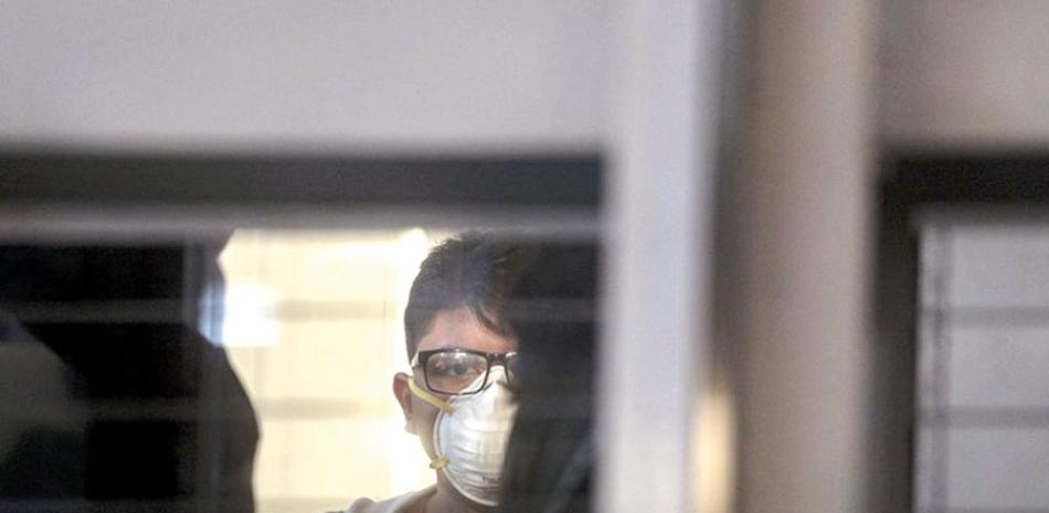 Un pasajero con una mascarilla usa un elevador antes de abordar un vuelo en el Aeropuerto Internacional Arturo Benítez, en Santiago de Chile.