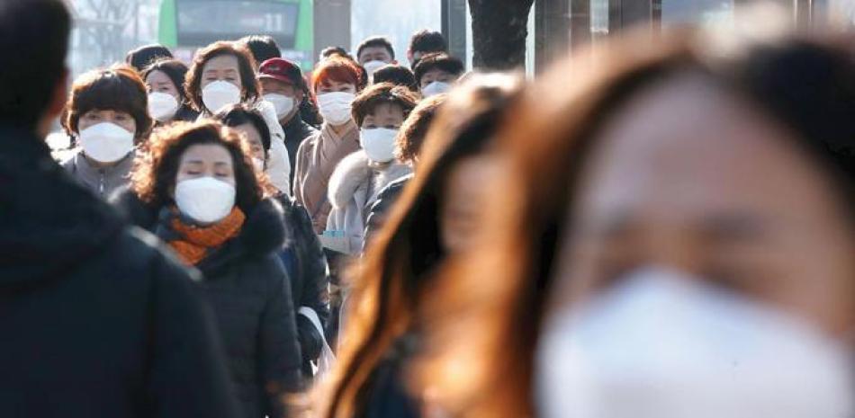 Las personas que usan máscaras faciales en Seúl. Corea del Sur registra más de 6,000 casos de Covid-19. / AFP