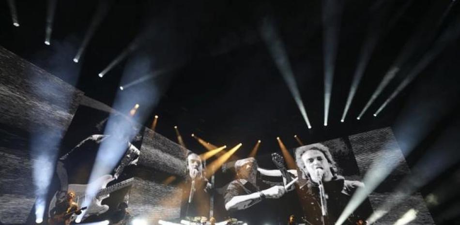 Con el difunto cantante Gustavo Cerati en pantalla, Charly Alberti de Soda Stereo toca durante el primer concierto de su gira "Gracias totales", el sábado 29 de febrero del 2020 en Bogotá. (AP Foto/Fernando Vergara)